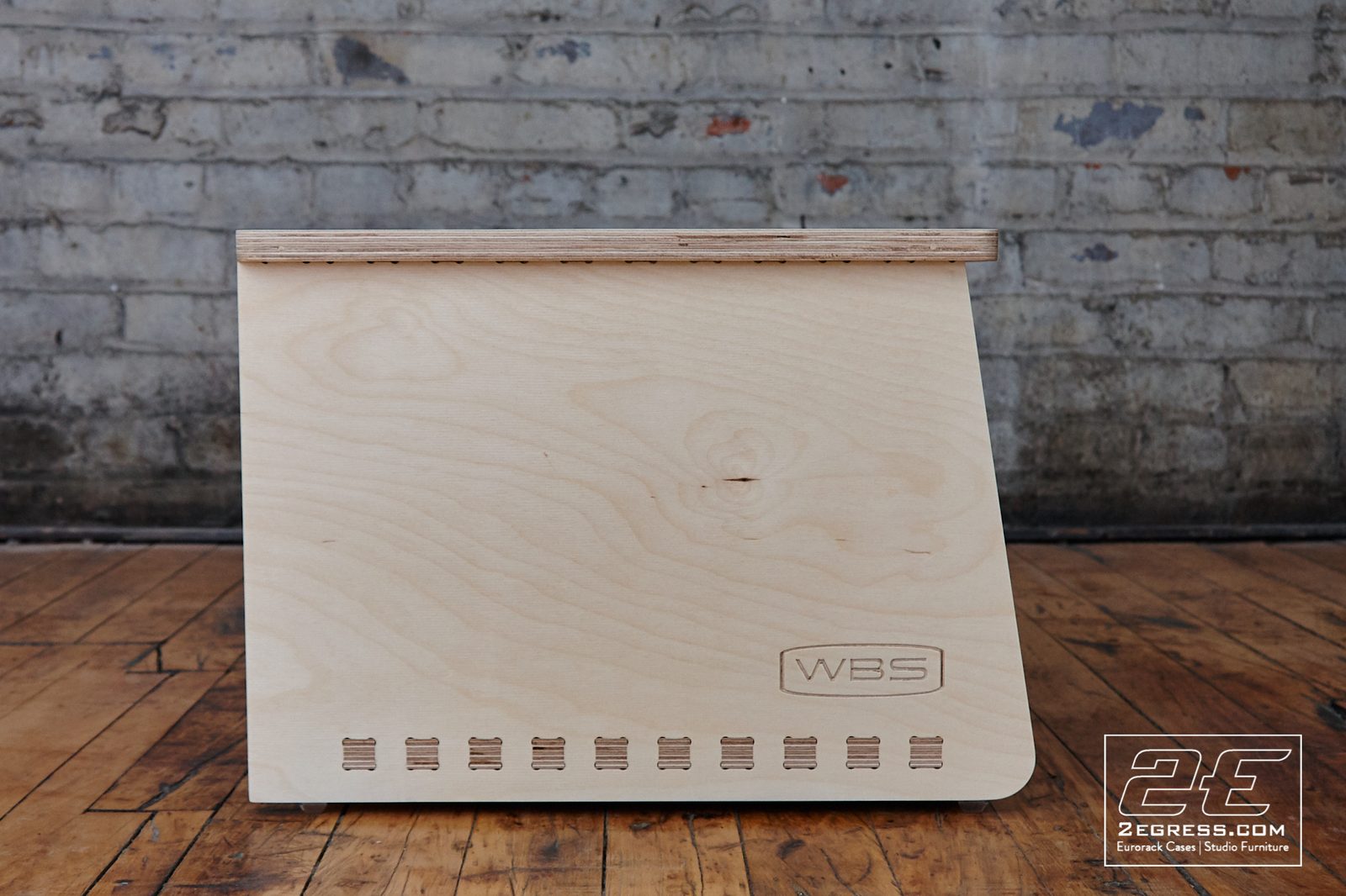 Dauntless Slant Rack Series | natural birch finish, straight-on view of the slanted face with engraved WBS logo | 2Egress