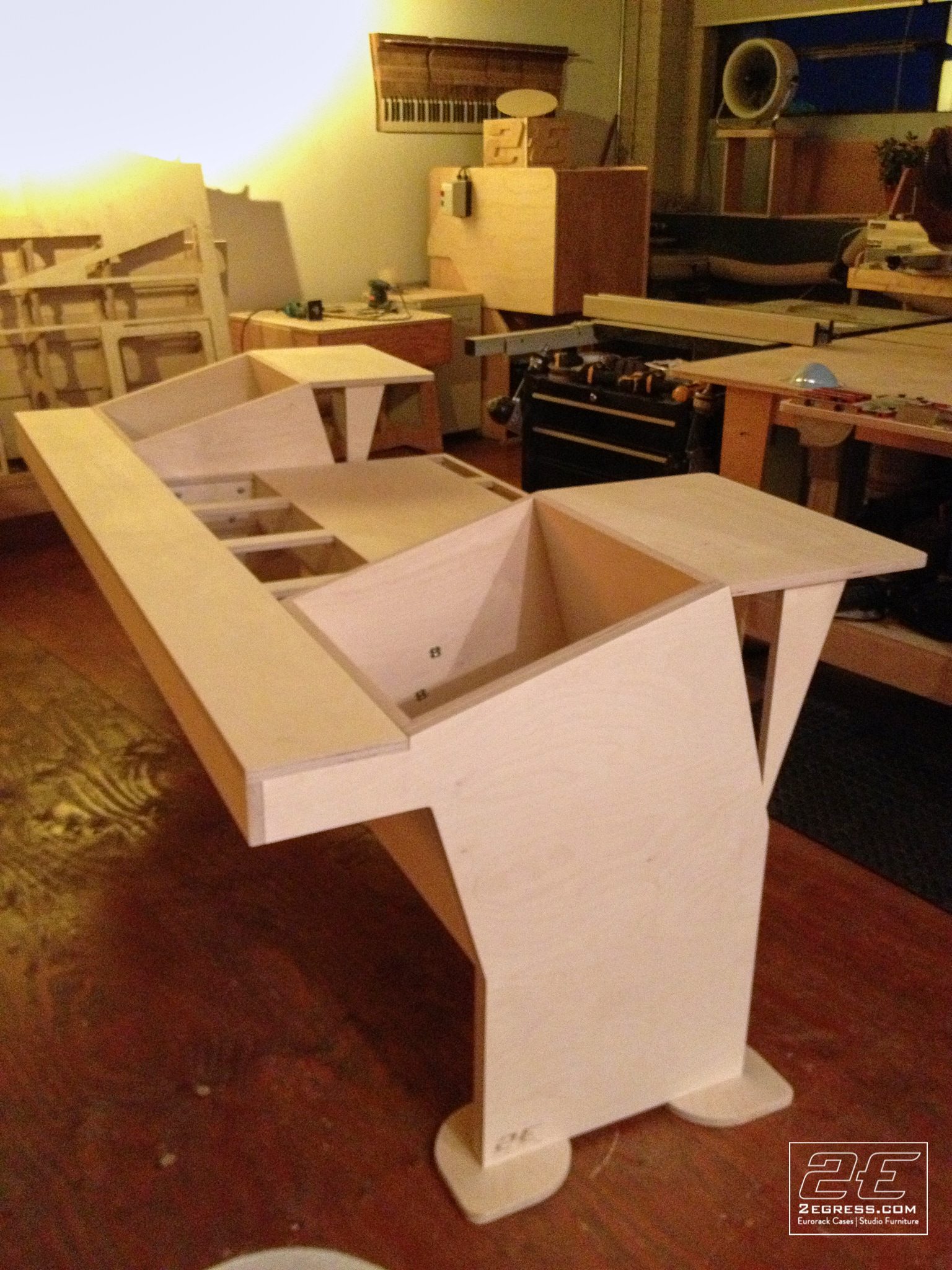 Stealth for Avid System 5 desk | raw plywood construction, angled side view in the workshop | 2Egress