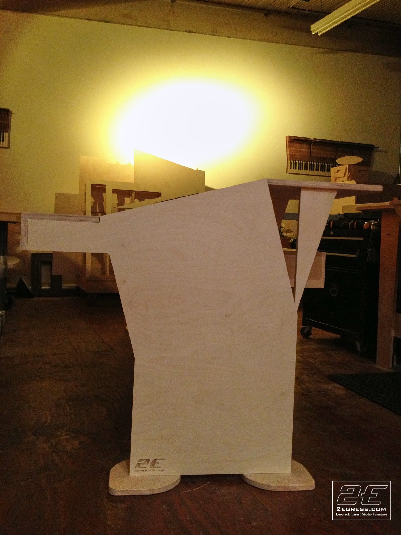 Stealth for Avid System 5 desk | raw plywood construction, front angled view under warm workshop light | 2Egress