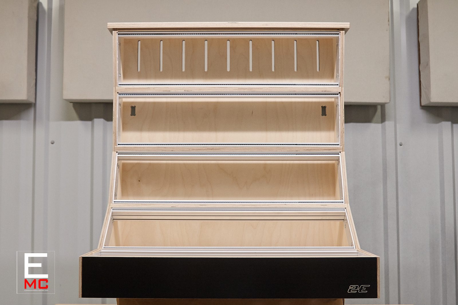 15U Steep eurorack case | single-width case, straight-on front view with empty rails, black side panels against acoustic foam wall panels | EurorackModularCase