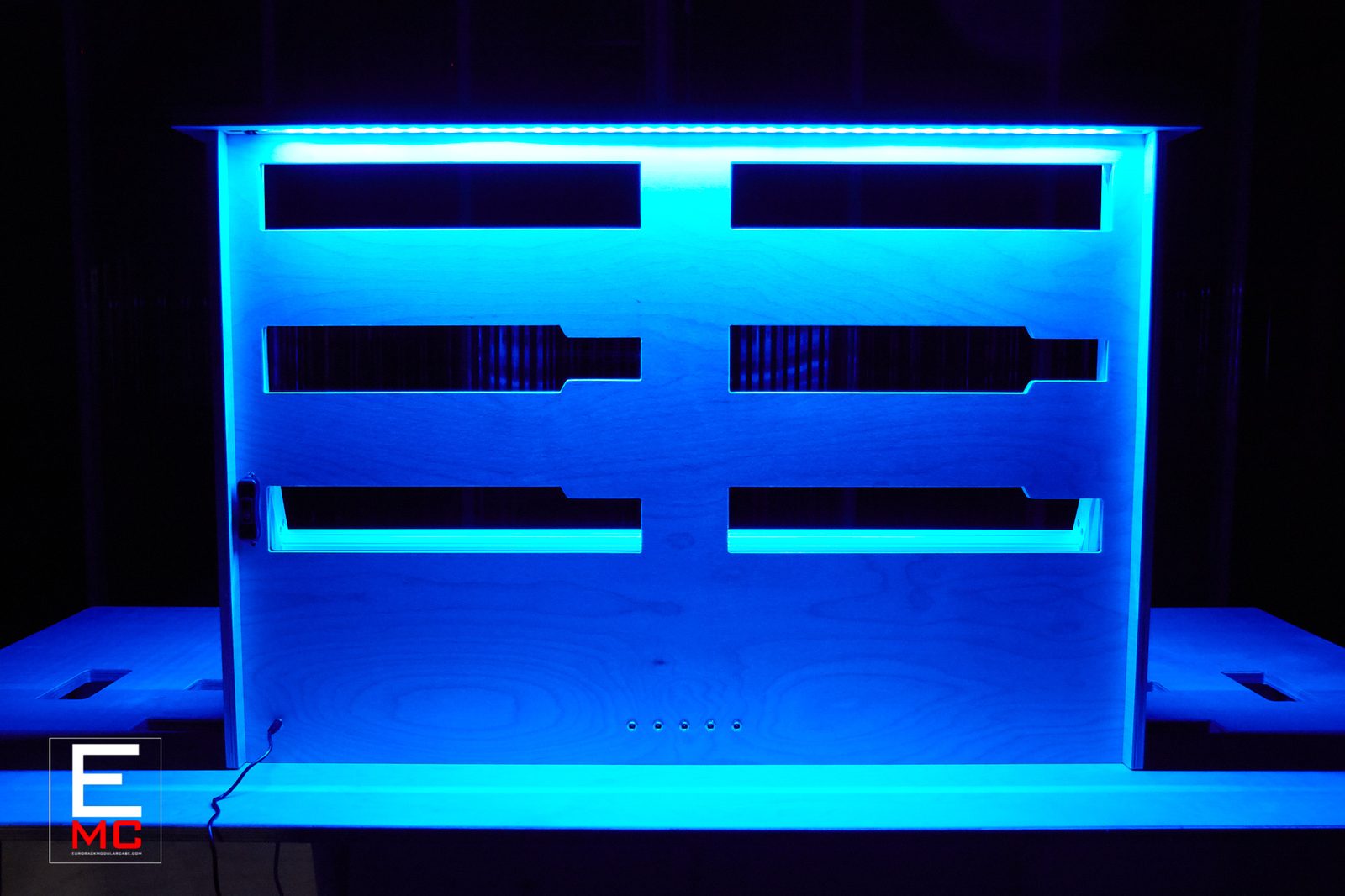18U The Blue eurorack case | Wide front view under blue LED lighting on its lit worktable | EurorackModularCase