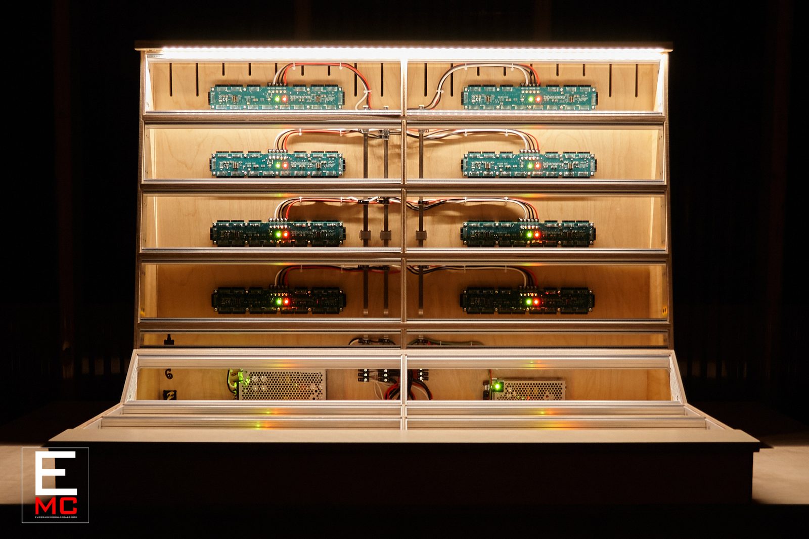 22U Jupiter eurorack case | Moody front view under green lighting with a mix of teal and dark green busboards installed | EurorackModularCase