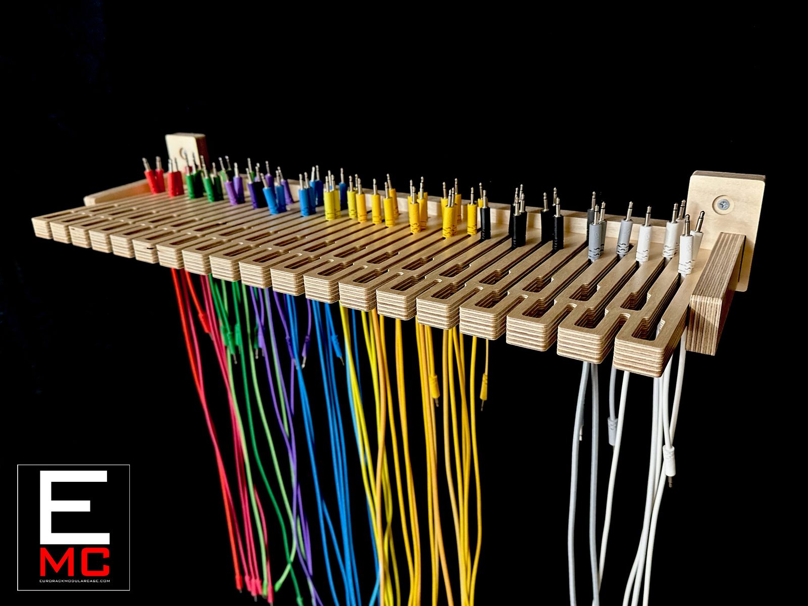 WM24 wall-mount cable hanger loaded with patch cables, opposite three-quarter angle against a black background | EurorackModularCase