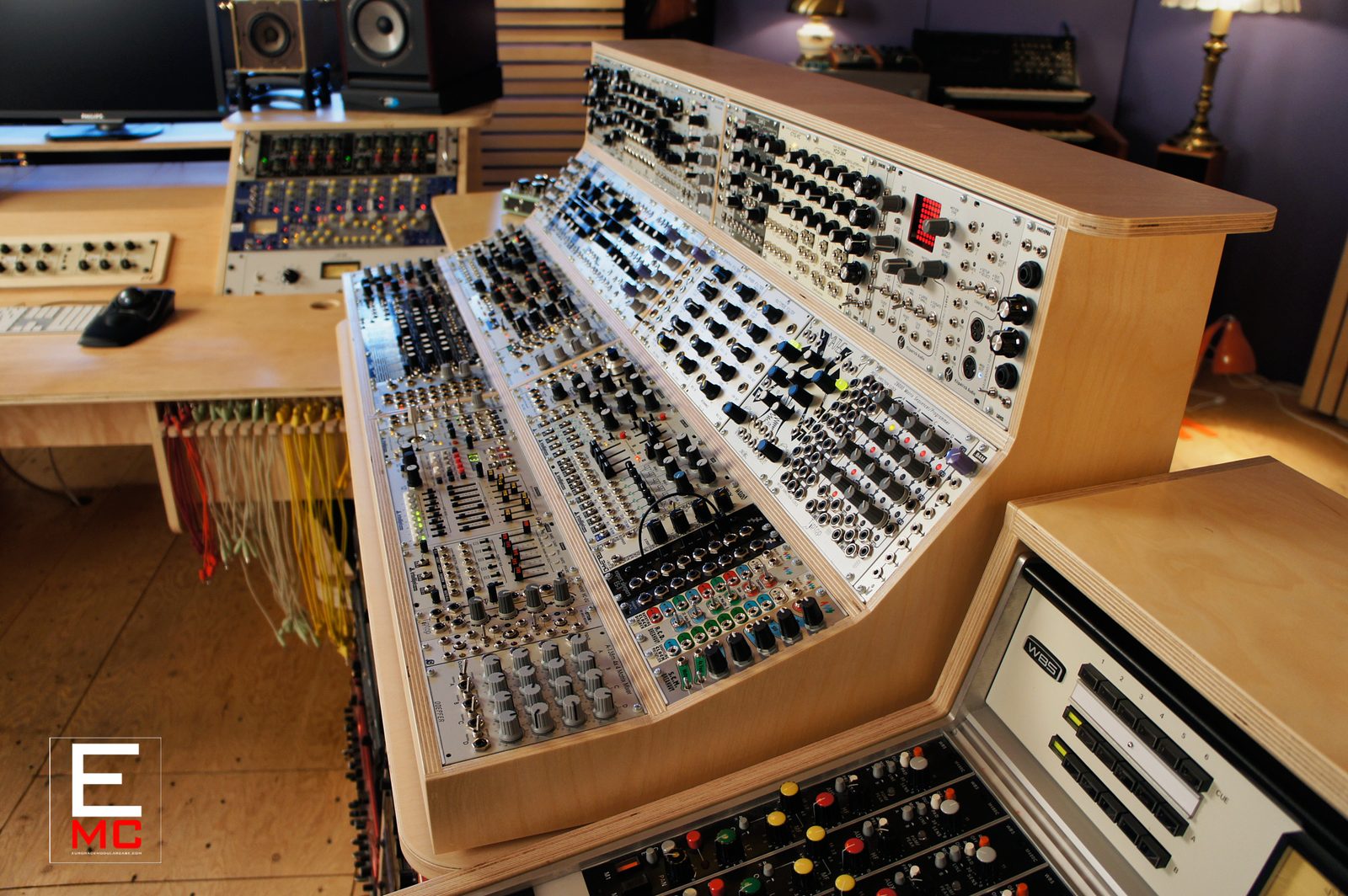 Damian Taylor | His fully patched 12U Golden Ratio eurorack case with racks of patch cables hanging beside the desk | Studio Egregia
