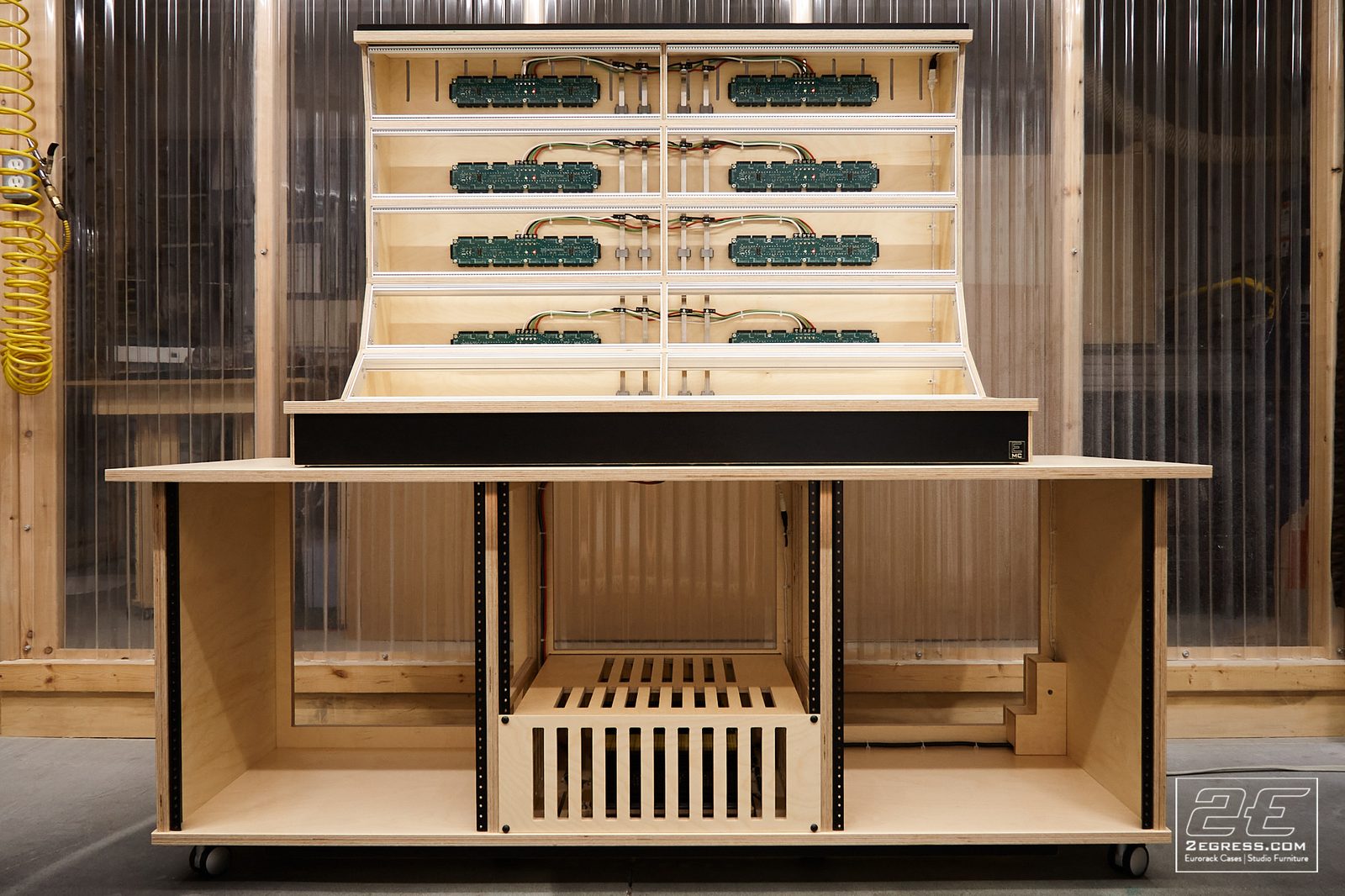 Lev Perrey | Unfinished 18U Lander eurorack case shell with empty module rails and exposed wiring, on a wheeled base | Studio Egregia