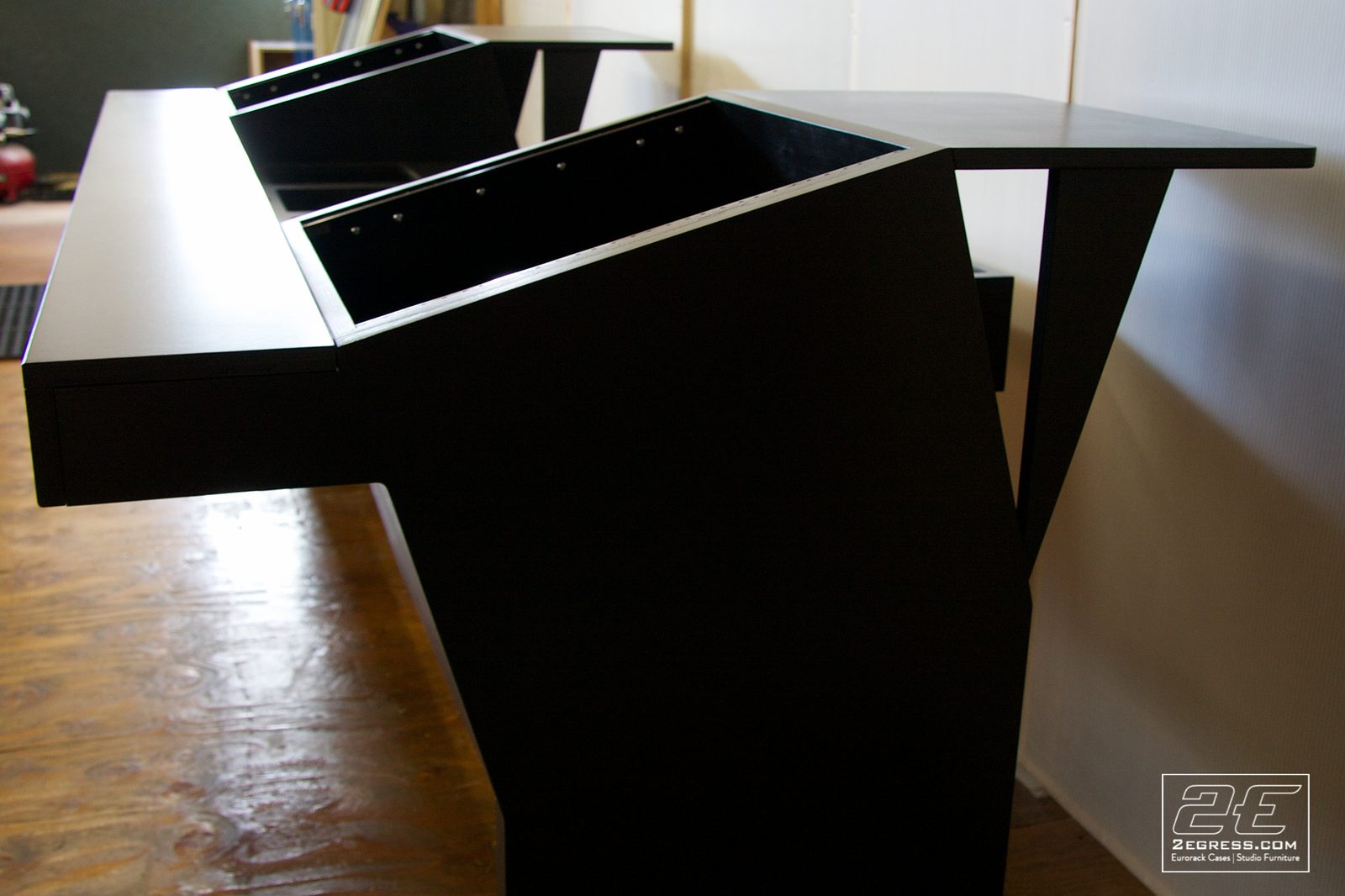 Ron Skinner | Close-up of the black desk's angled corner and leg joinery | Studio Egregia
