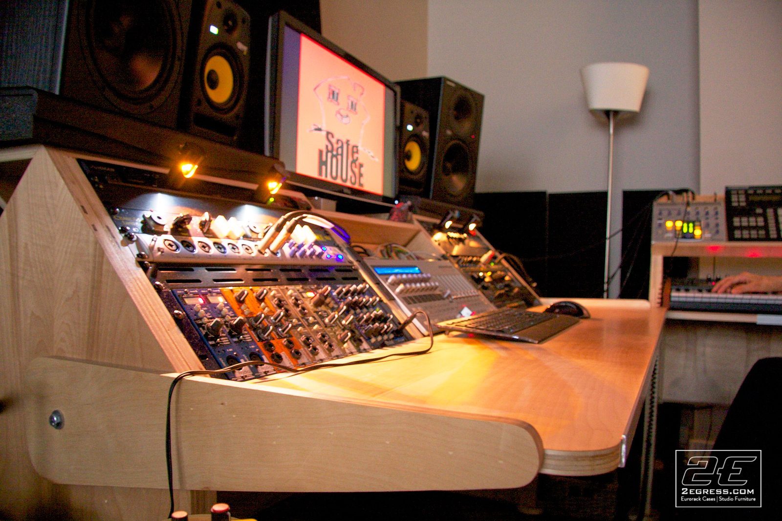 Steven Mek | 'Low Rida' desk in use with mixing gear and a monitor displaying 'Safe House' | Studio Egregia